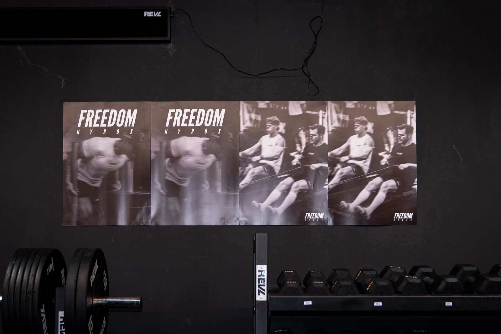 FREEDOM HYROX class posters mounted on the wall at REVL gym