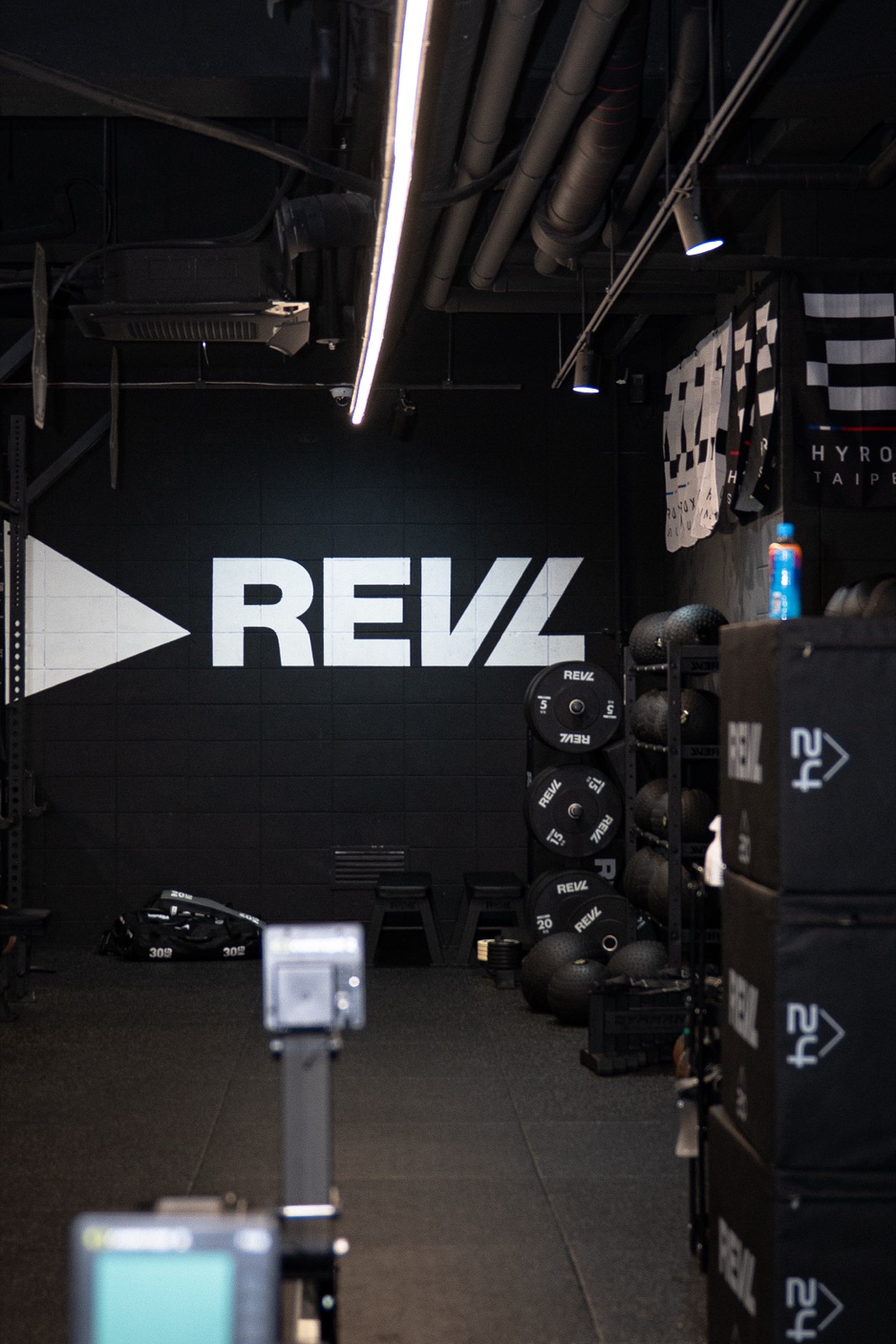 Interior of REVL HYROX training center in Gangnam, Seoul — REVL logo wall and HYROX city banners