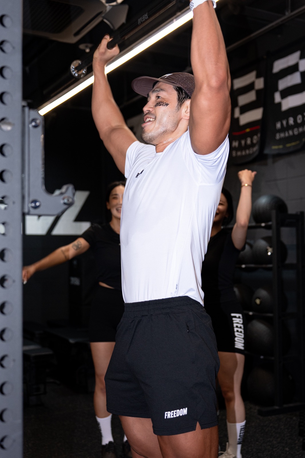Participant pulling the SkiErg during the REVL x FREEDOM HYROX class with crew cheering behind